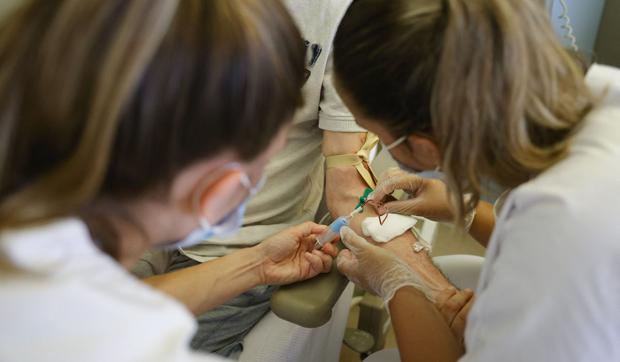 Medical staff injecting a needle into a patient (Photo: AFP)