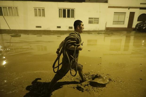 Un ciudadano caminando sobre un camino lleno de agua (Foto: GEC)