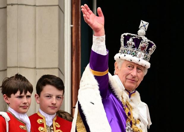 El rey Carlos III de Gran Bretaña saluda desde el balcón del Palacio de Buckingham, en Londres, luego de su coronación, el 6 de mayo de 2023. (Foto de Leon Neal/PISCINA/AFP)